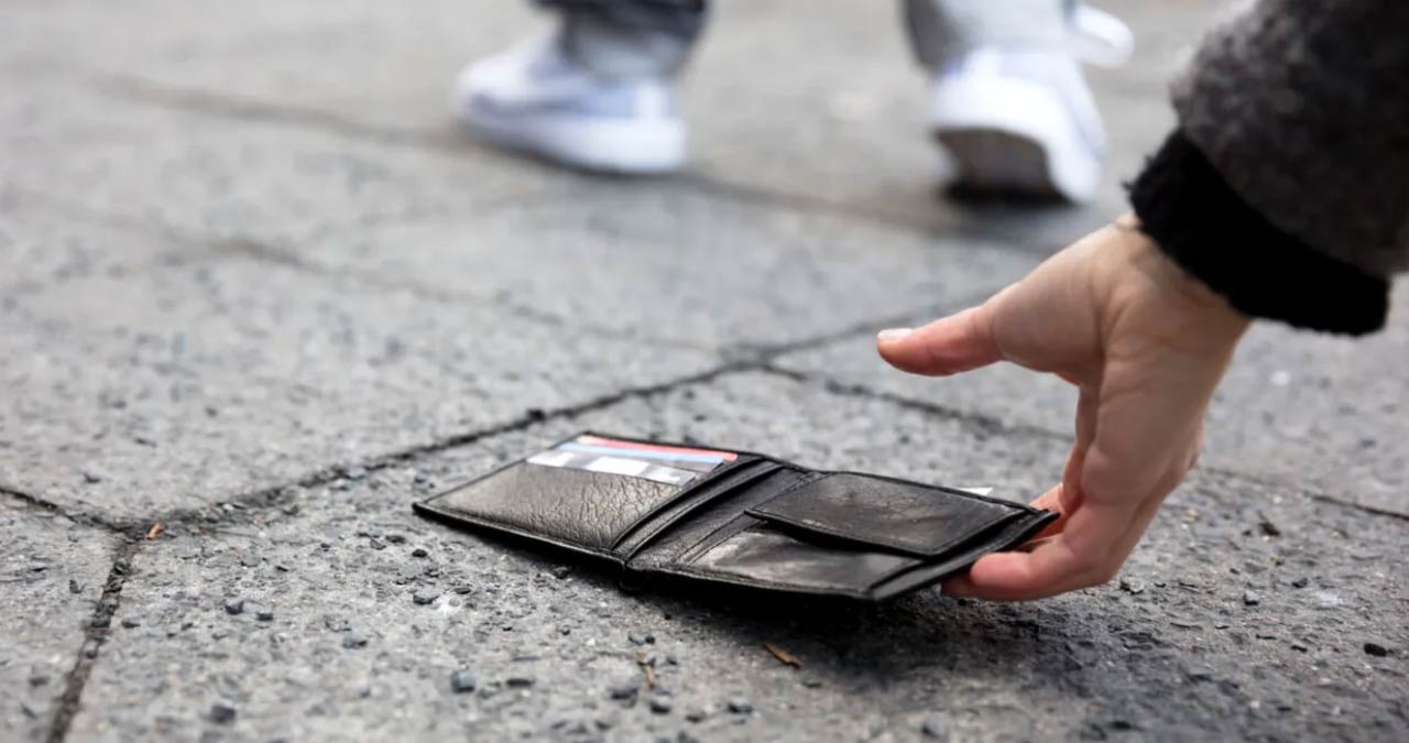 Persoană stresată folosind aplicația bancară pe telefon pentru a bloca un card după pierderea portofelului